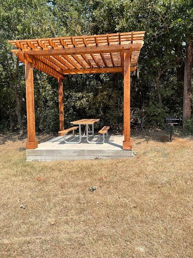 a picnic table under a pergolized structure at The Kings Lofts